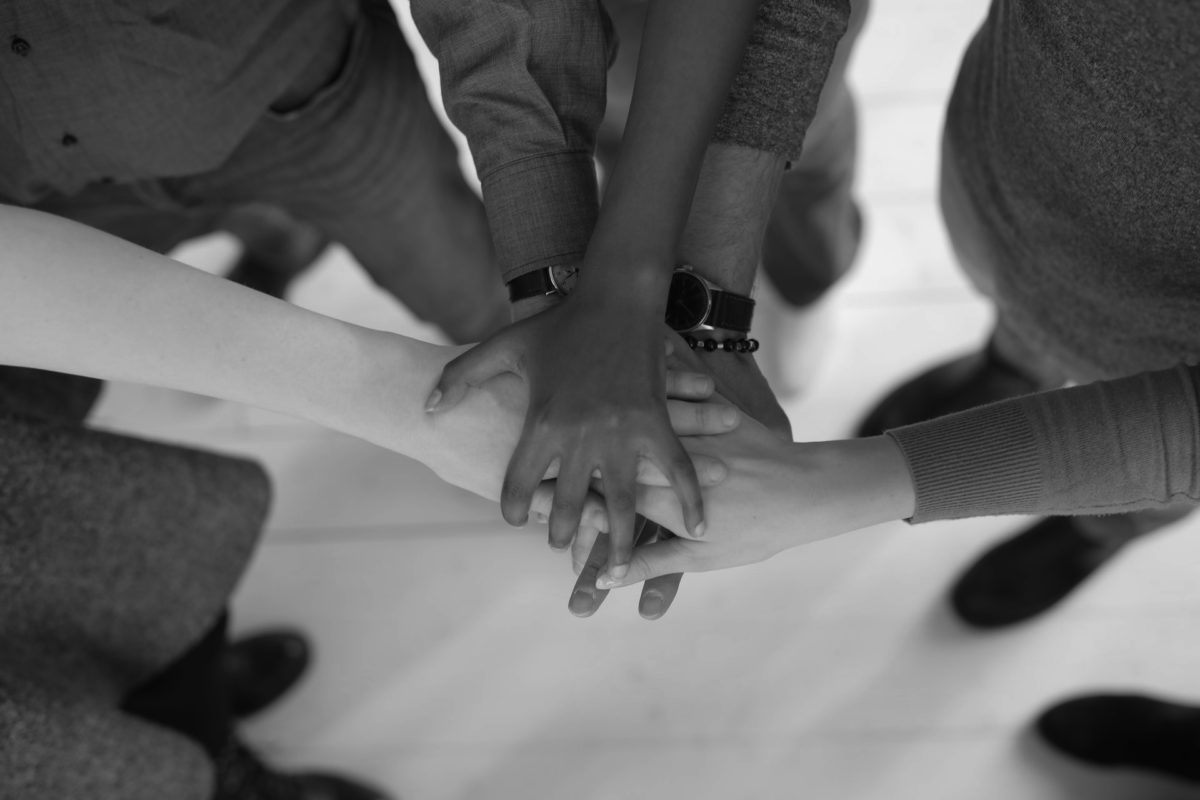 A team in a huddle with hands in